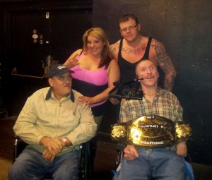 Cottage of the Shoals residents George Carroll, left, and John Benson, right, with two New Generation Wrestling stars and the championship belt.