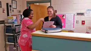 Dadeville Healthcare Center Social Services Director Katie Morgan, right, discusses a resident's medical chart with Certified Nursing Assistant Sheneequa Banks.