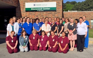 Several Glenwood Center staff members pose for a picture outside the center's main entrance.