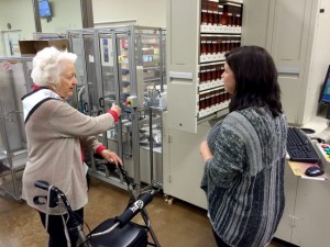 Pharmacy Technician Magan McMillian explains to Ms. Alabama Nursing Home Sylvia Holland how a computer controlled robot dispenses prescription medicine.