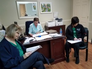 From the left, MDS Coordinator Angie Hudson, RN, Admissions Coordinator Theresa Jones and Kim Allred review care plans for long-term care residents.