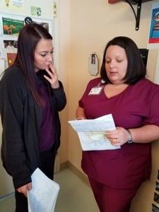 Social Service Director Alyssa Aikens, LBSW, and Rehab Unit Secretary Amanda Henley discuss a patient's discharge plan.